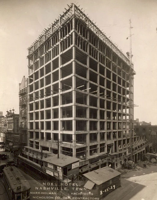 A historic photo of the Noel Hotel in Nashville, Tennessee, under construction in 1928, showcasing its steel framework and urban setting.