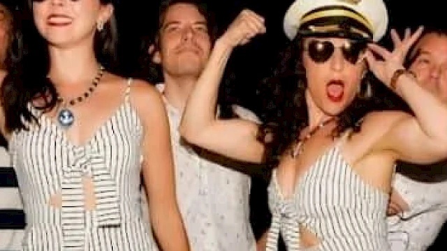 People in sailor-themed outfits strike playful poses, wearing captain hats and striped attire, exuding a lively and festive atmosphere.